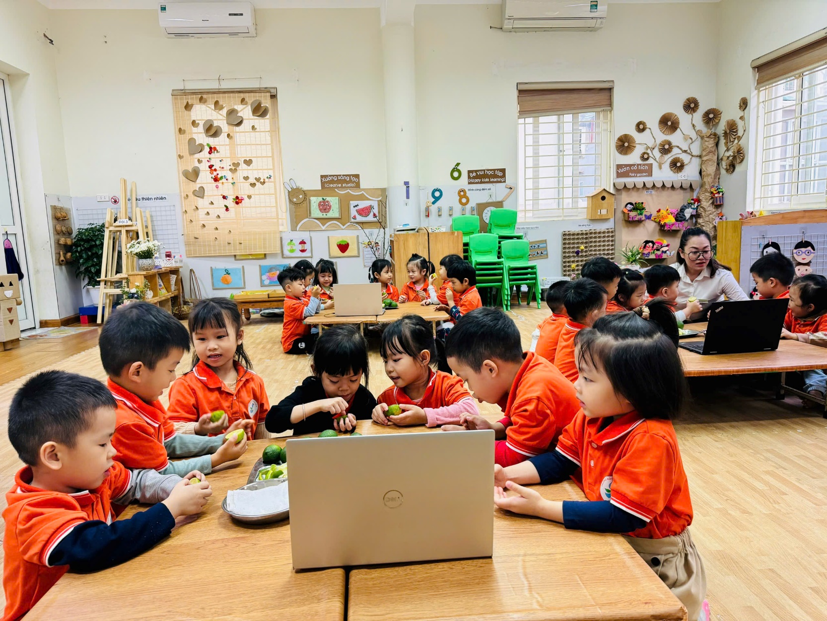 A group of children sitting at a table with a computer

Description automatically generated