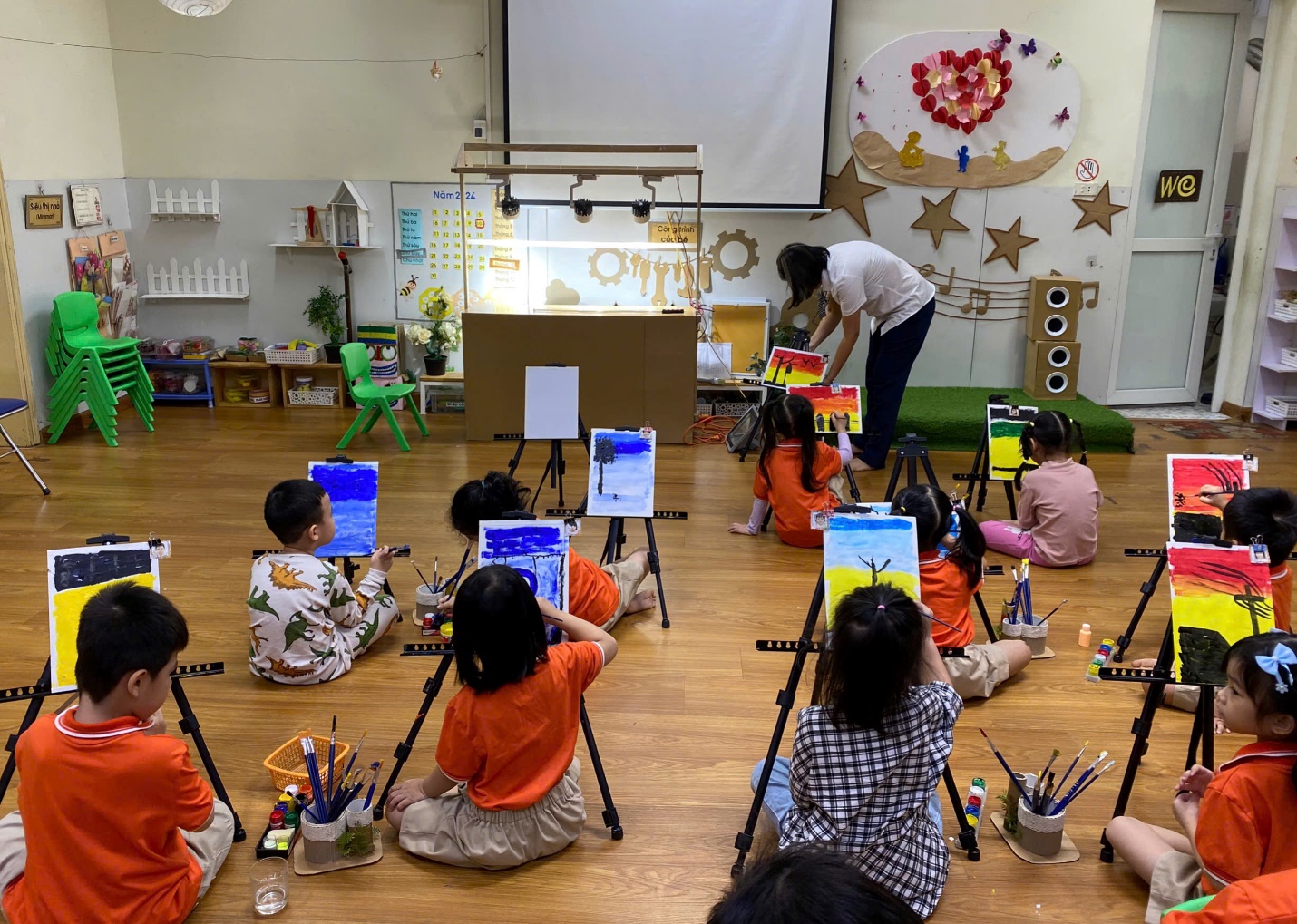 A group of children painting in a classroom

Description automatically generated