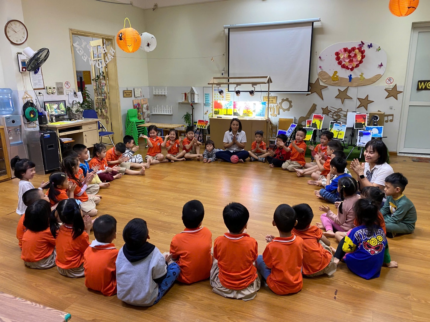 A group of children sitting in a circle

Description automatically generated