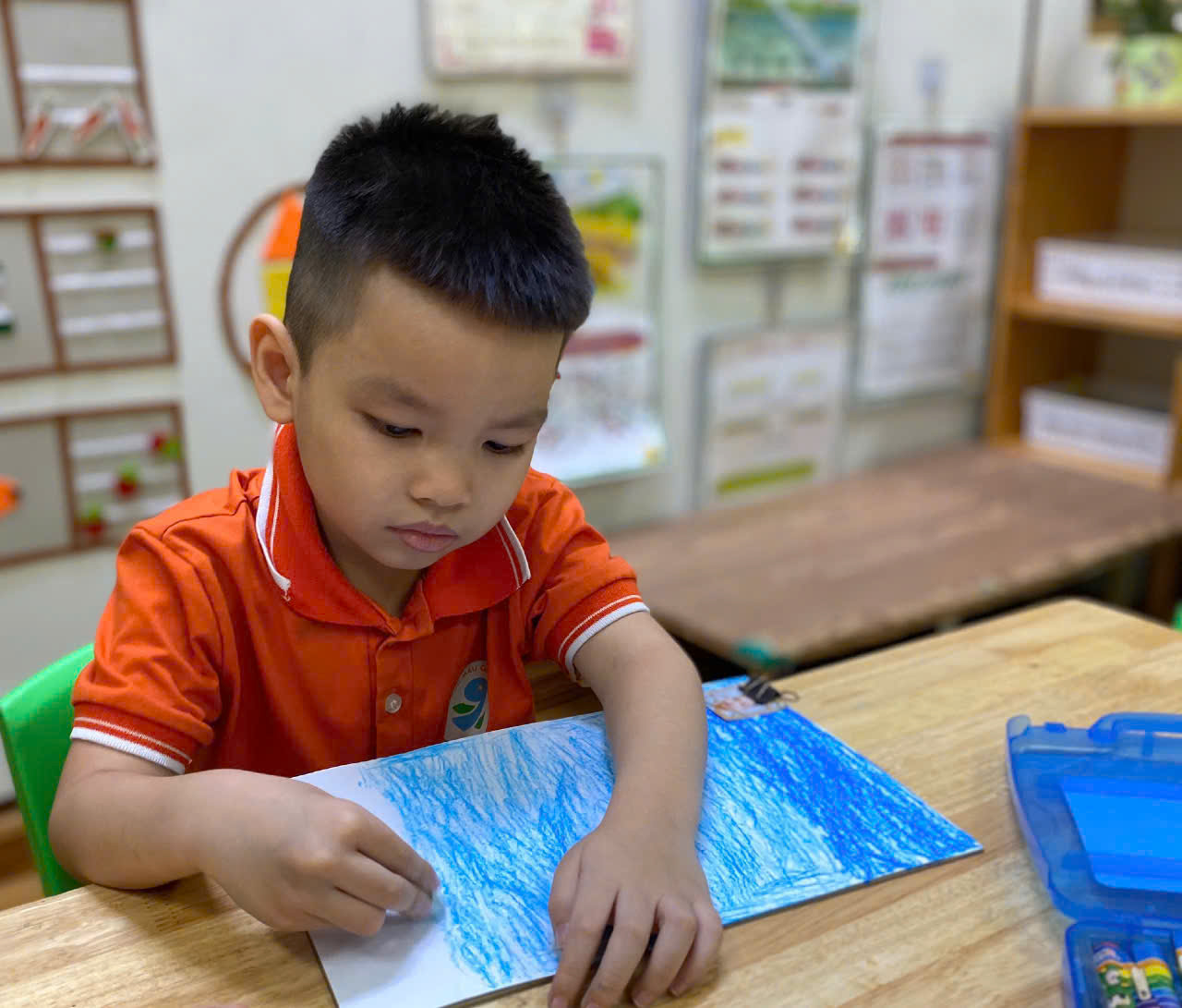 A child sitting at a table drawing

Description automatically generated