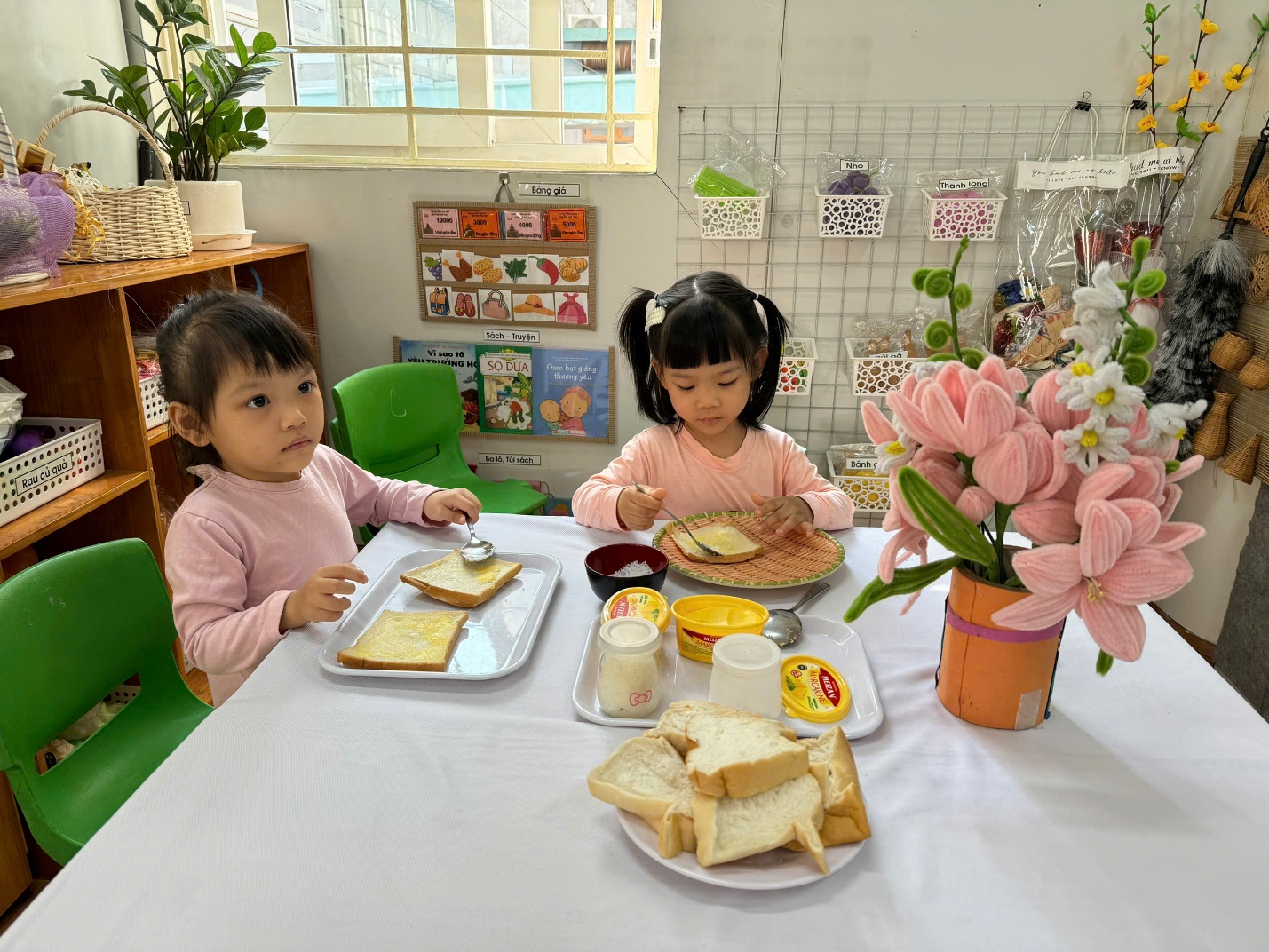 Two children sitting at a table eating food

Description automatically generated