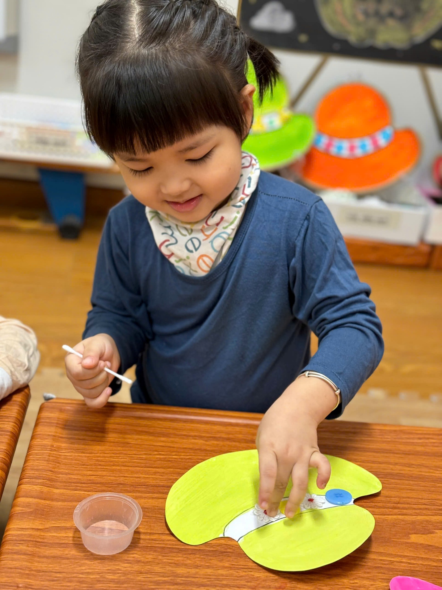 A child painting a yellow paper plate

Description automatically generated