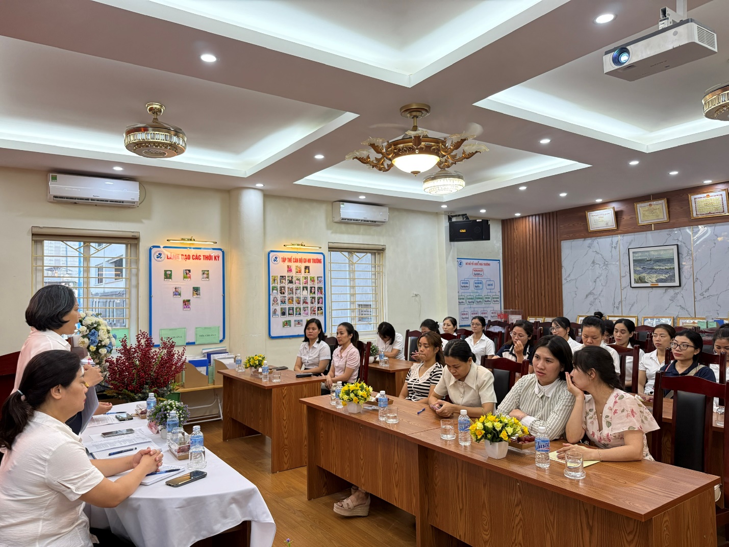 A group of people sitting in a room

AI-generated content may be incorrect.