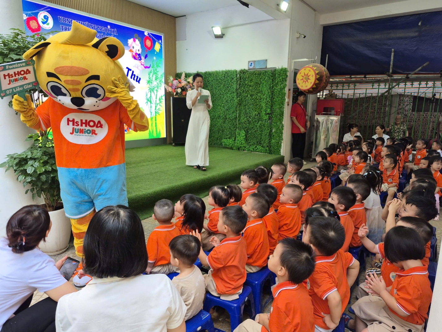 A person in a garment and a group of children sitting on chairs

AI-generated content may be incorrect.