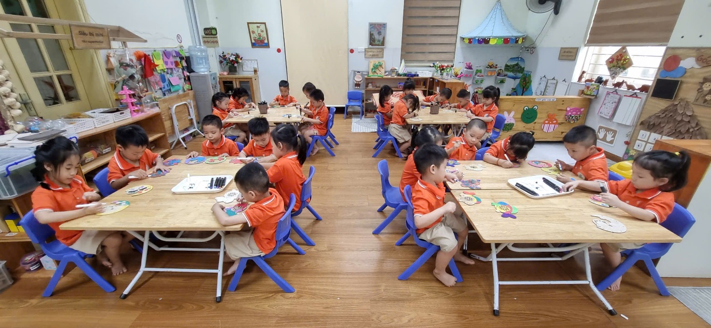 A group of children sitting at tables in a classroom

AI-generated content may be incorrect.