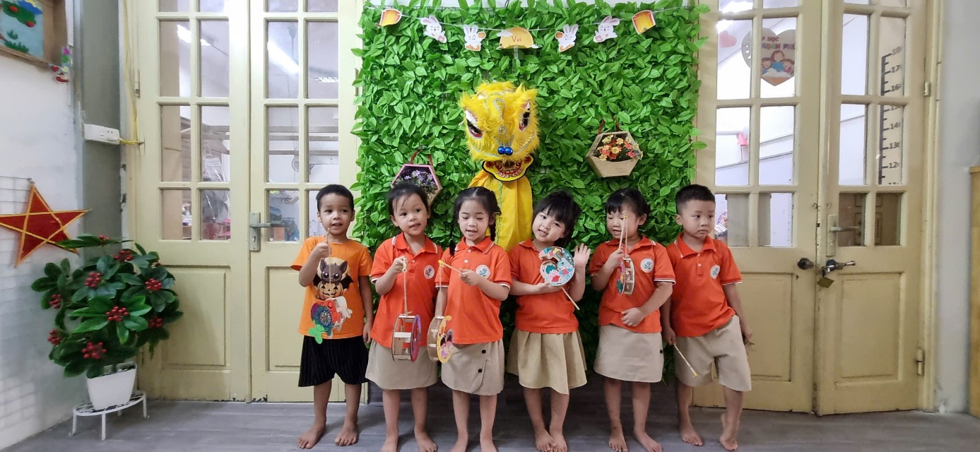 A group of children standing in front of a green wall

AI-generated content may be incorrect.