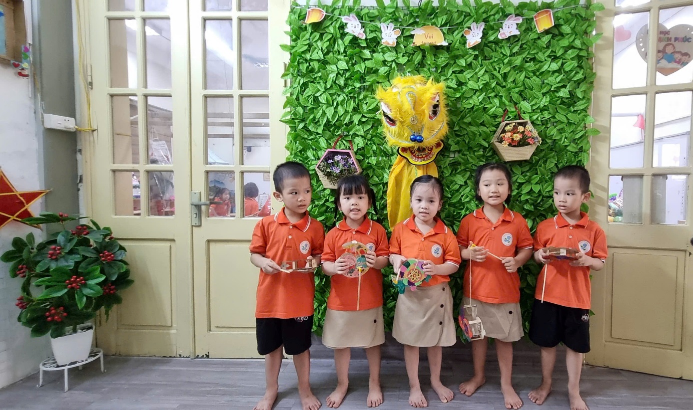 A group of children standing in front of a green wall

AI-generated content may be incorrect.