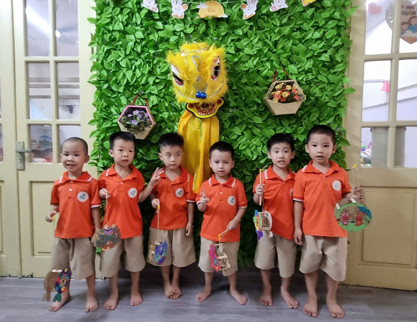 A group of boys in orange shirts standing in front of a green wall

AI-generated content may be incorrect.