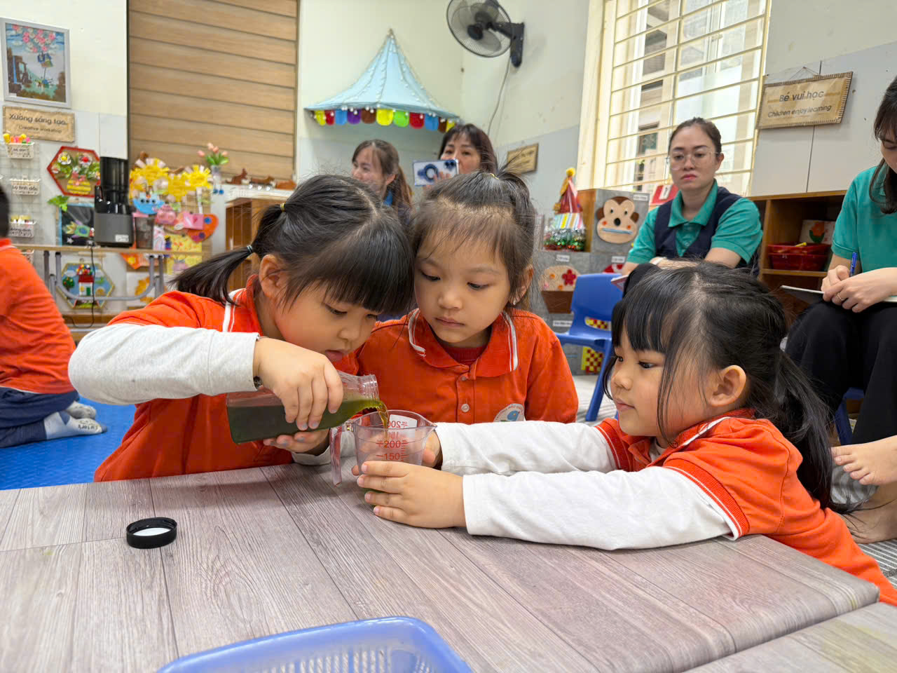 A group of girls pouring liquid into a cup

AI-generated content may be incorrect.
