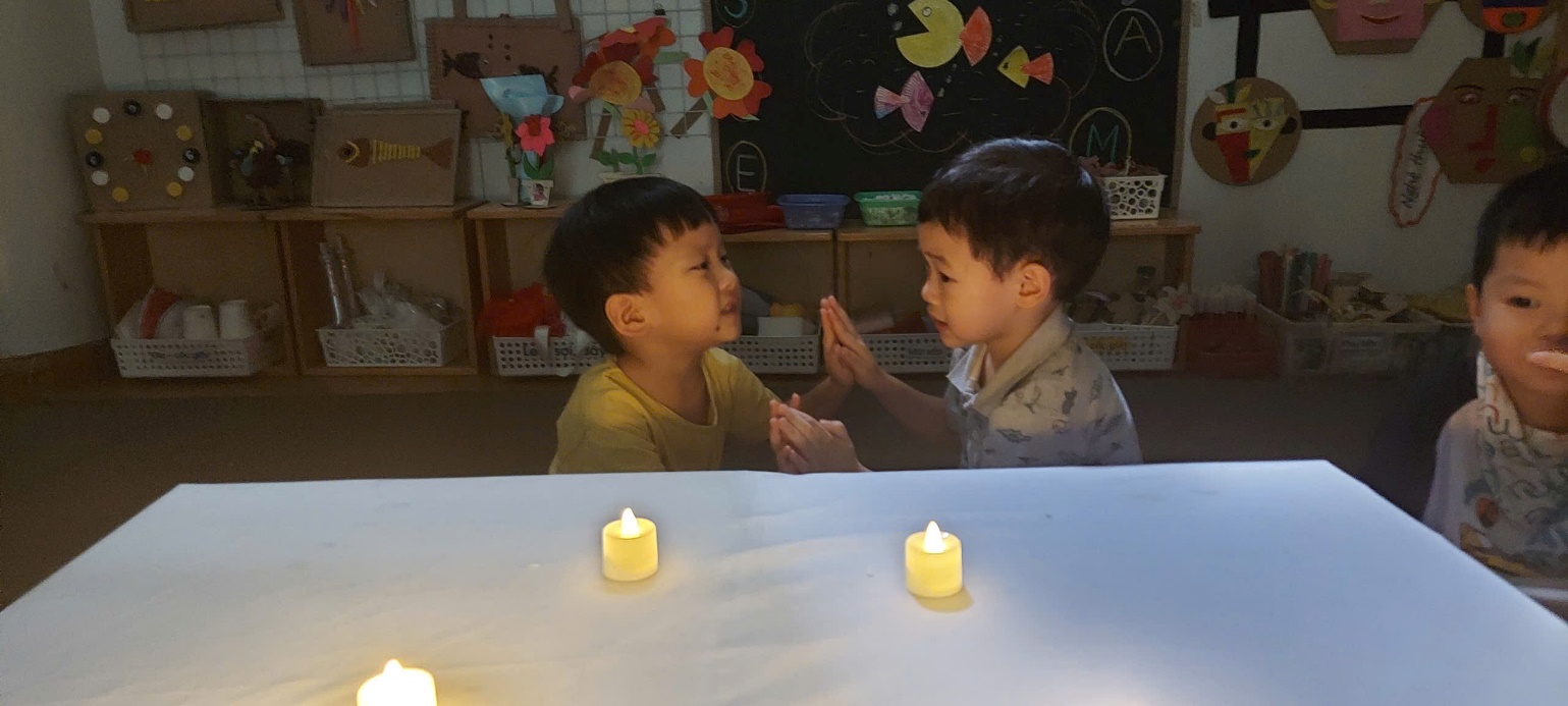 Two boys sitting at a table with candles

AI-generated content may be incorrect.
