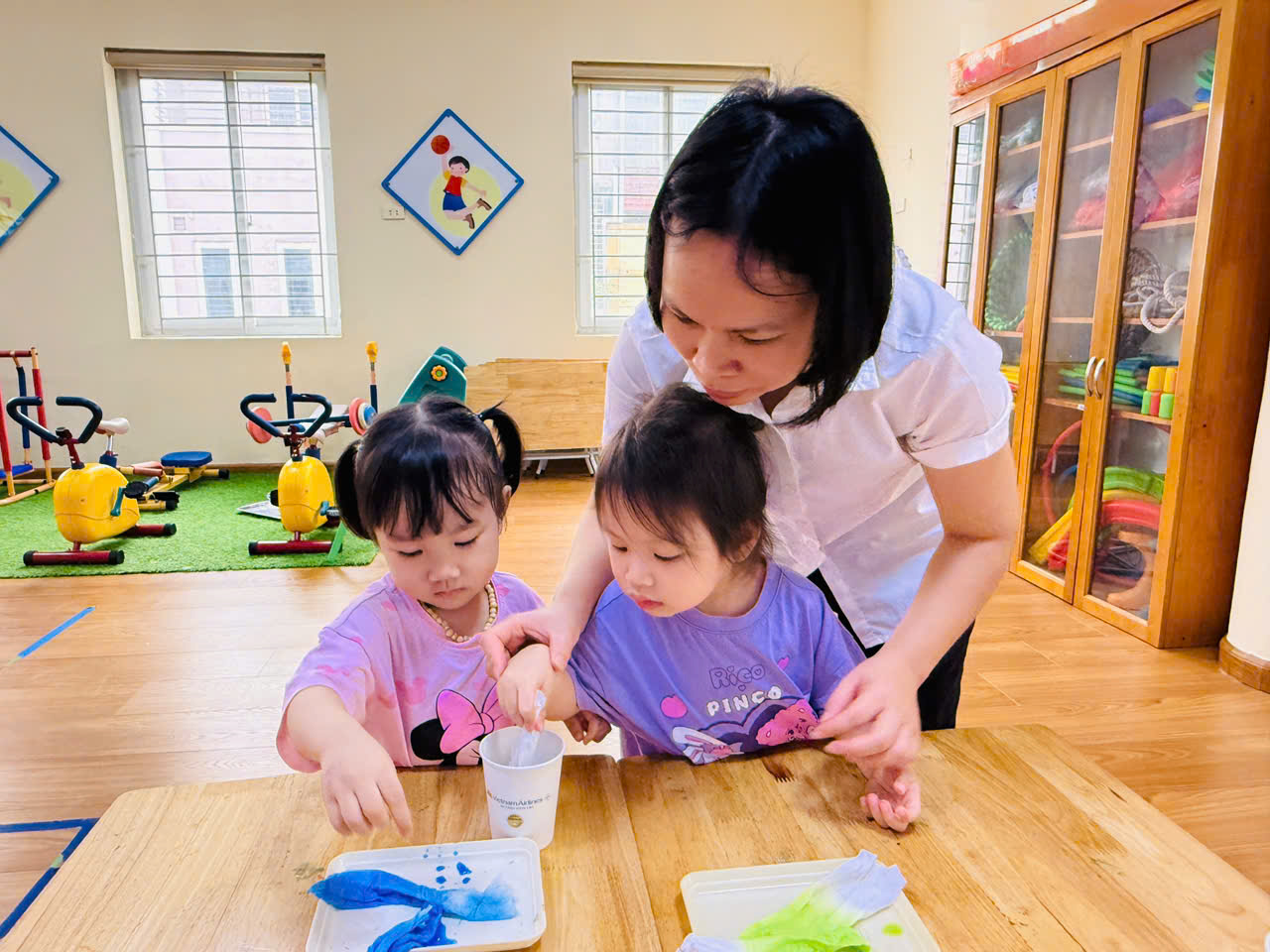 A person and two girls painting at a table
AI-generated content may be incorrect.