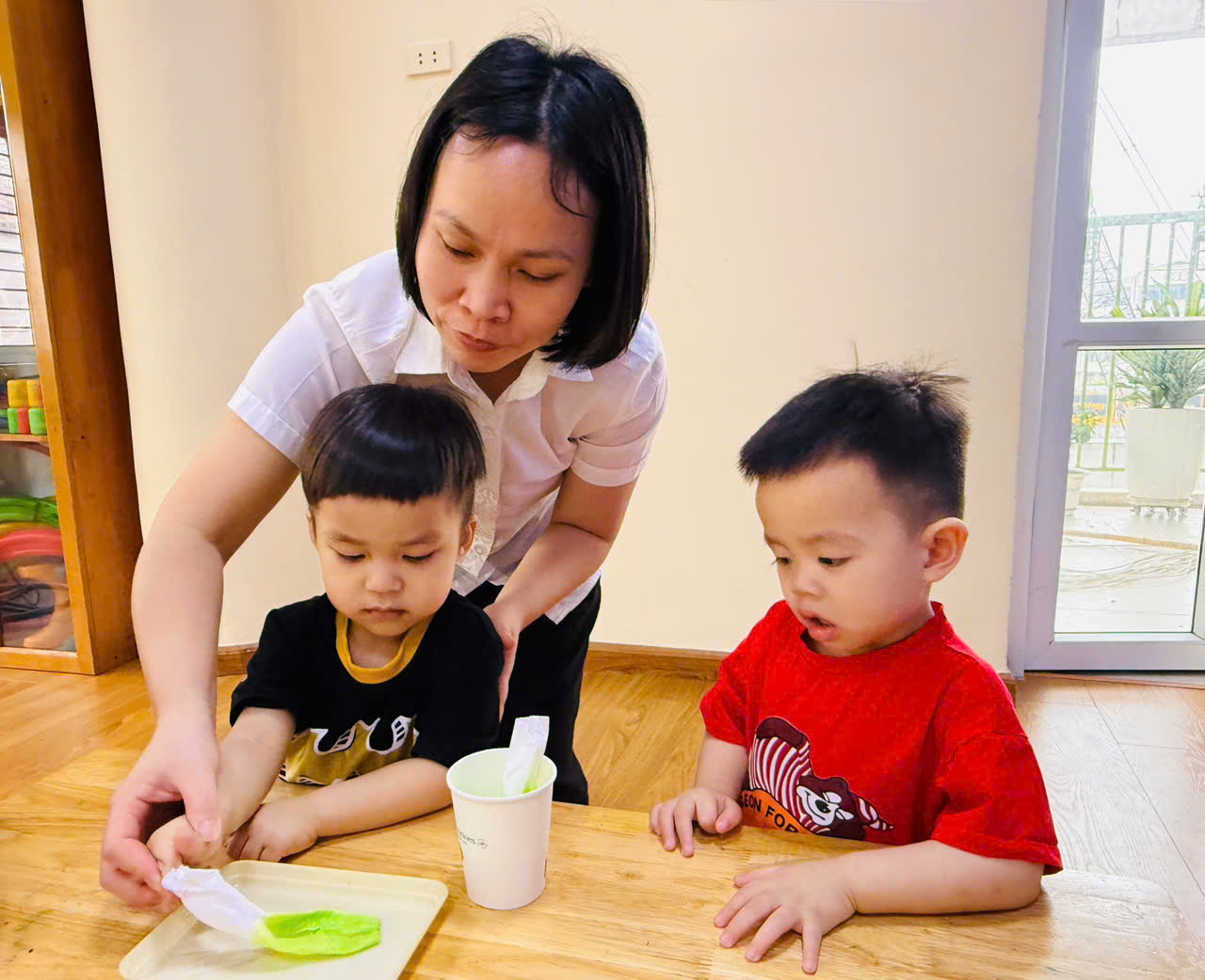 A person and two children sitting on the floor
AI-generated content may be incorrect.