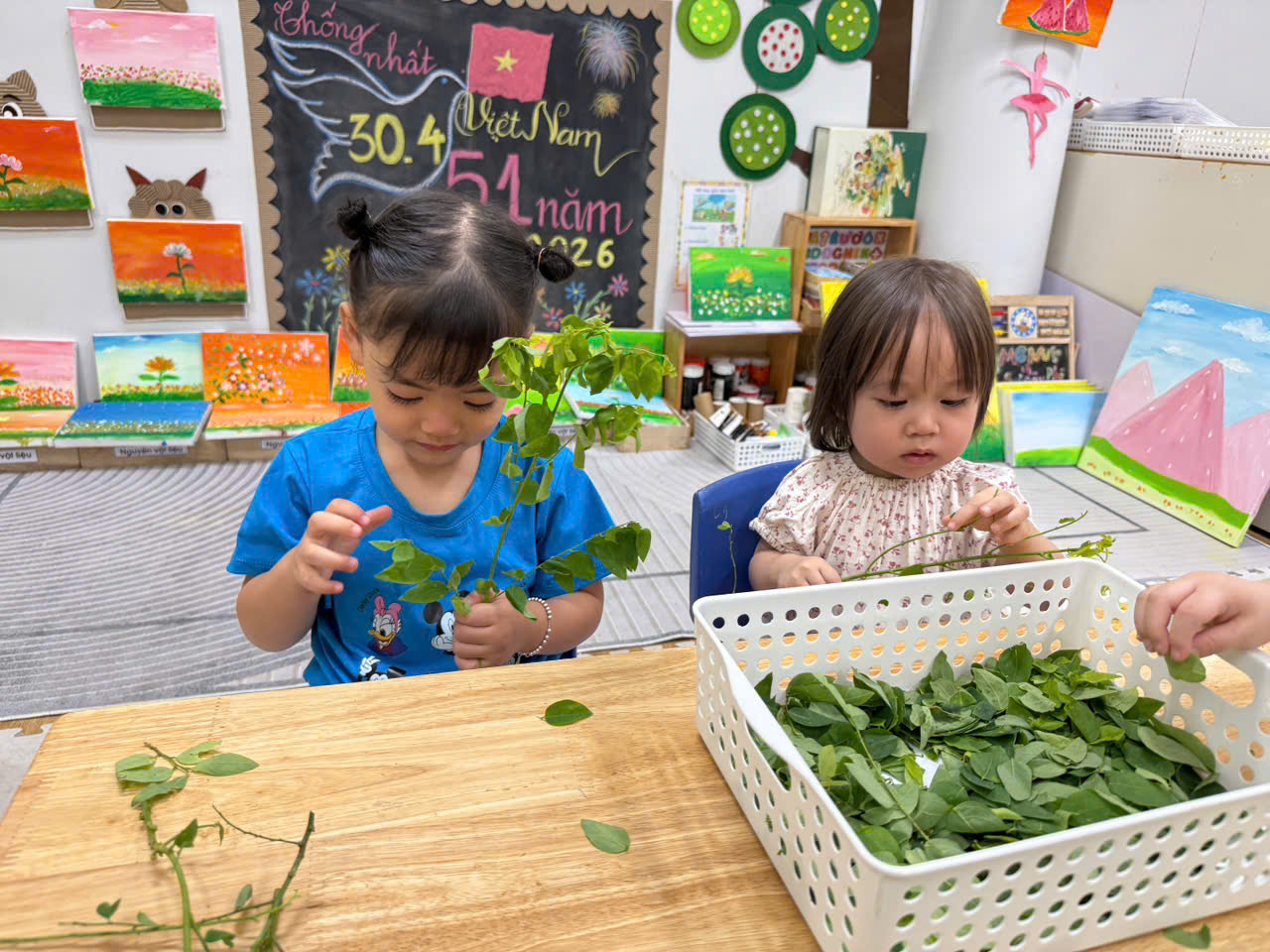 Two children sitting at a table with leaves
AI-generated content may be incorrect.