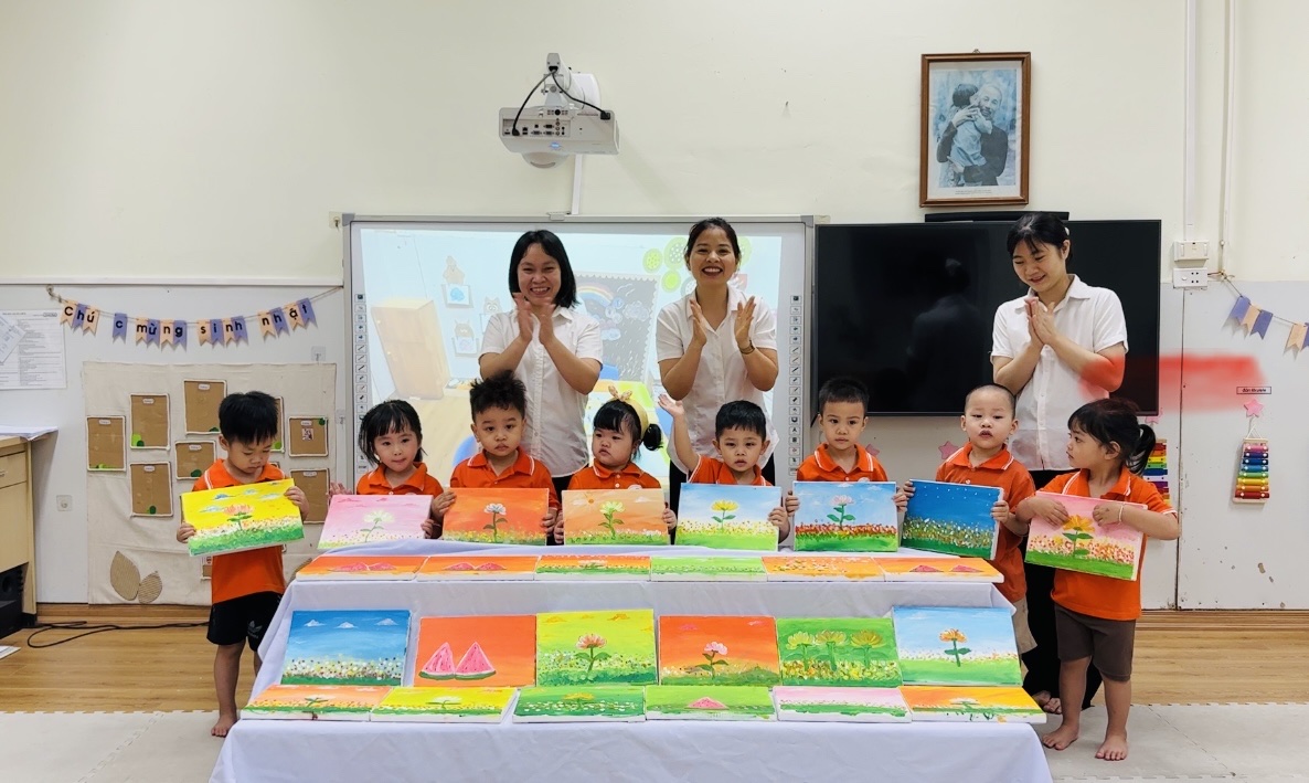 A group of children standing in front of a table with a white board
AI-generated content may be incorrect.